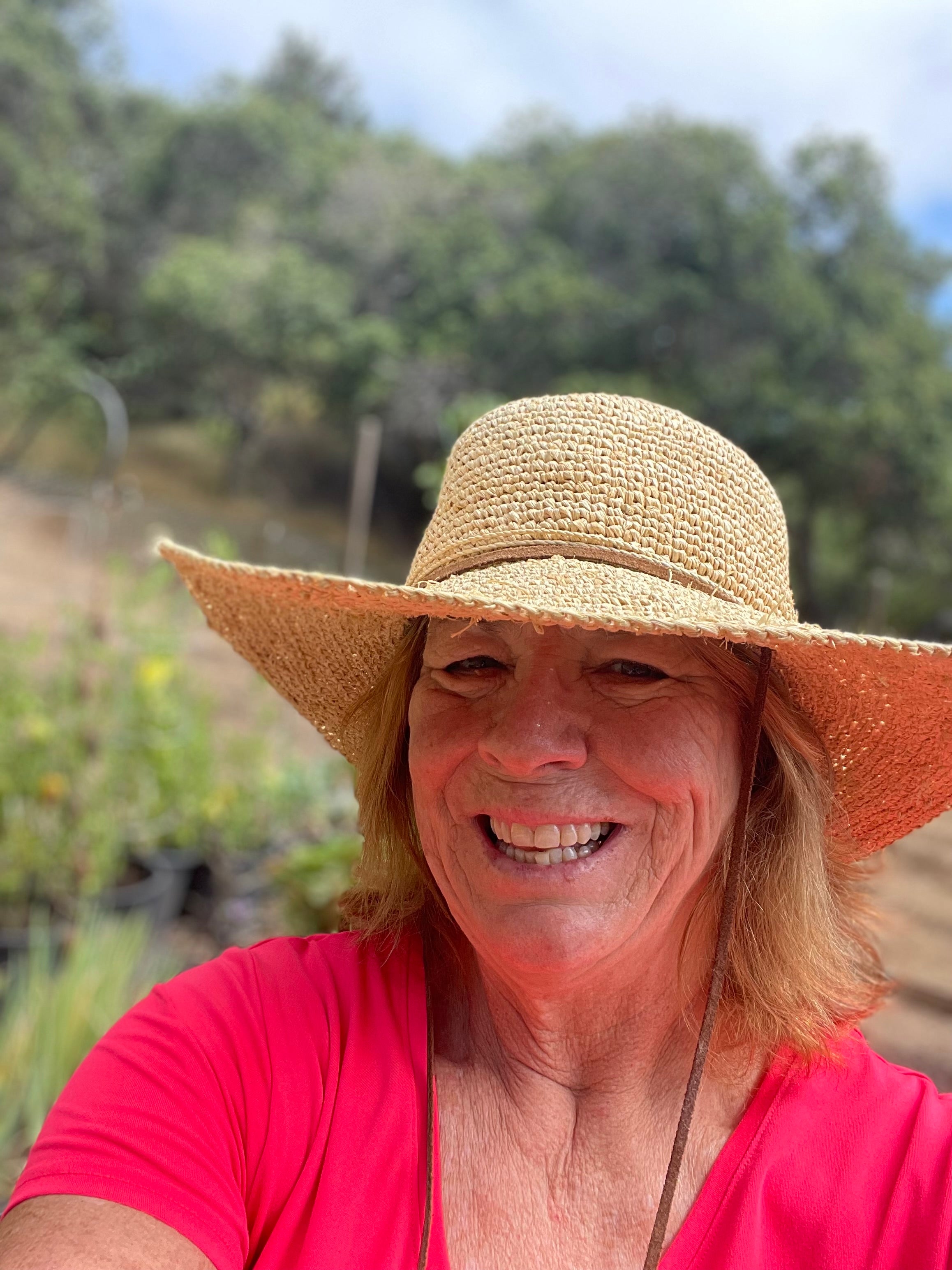 Woman wearing hat and smiling outdoors