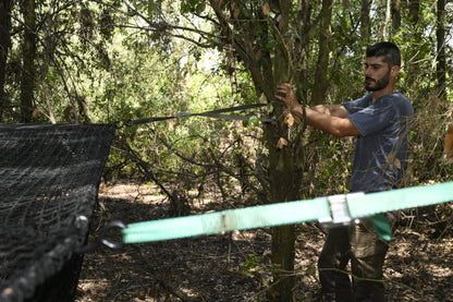 Man setting up a Pig Brig Net Trap in a forest